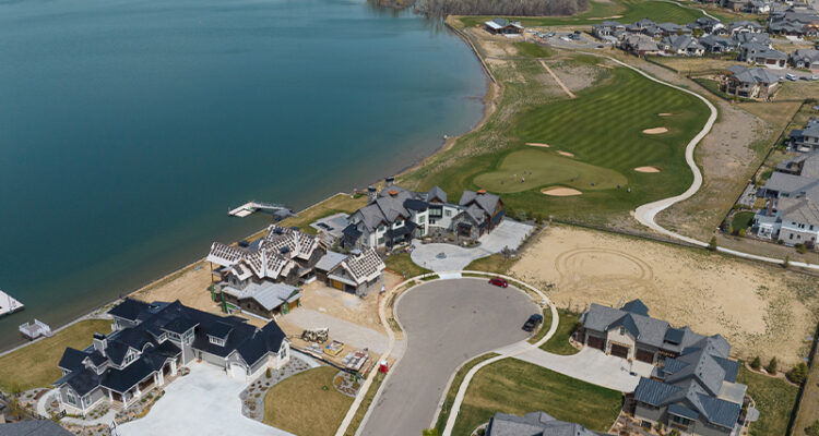 Aerial view of houses near a lake and golf course.