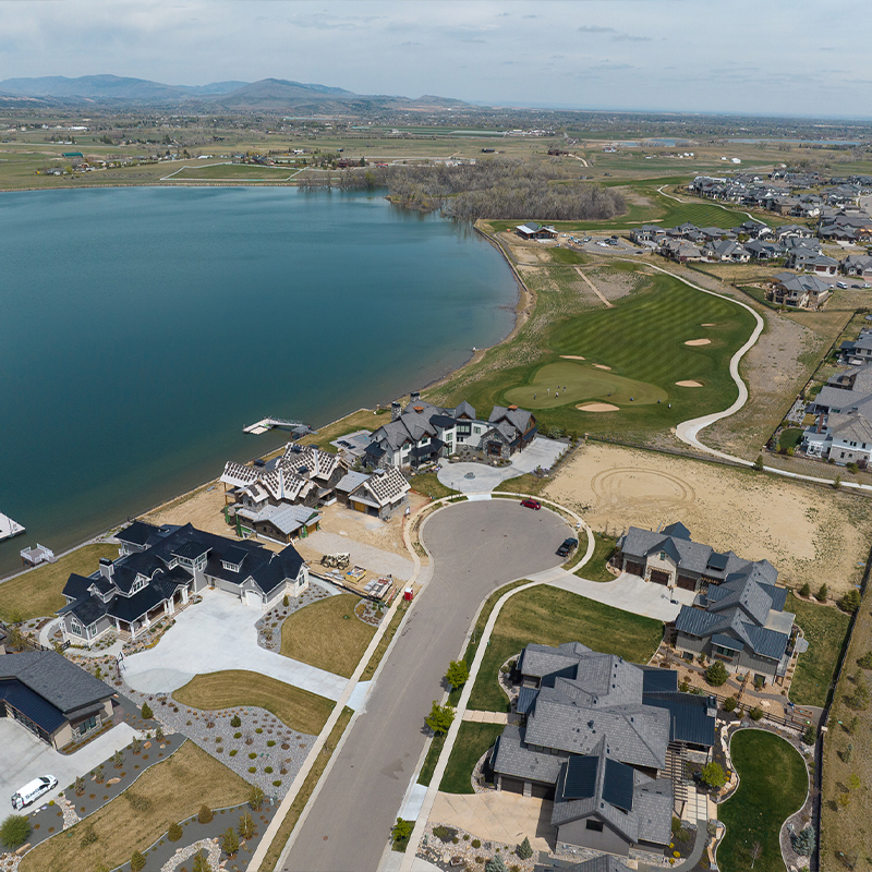 Aerial view of houses near a lake and golf course.
