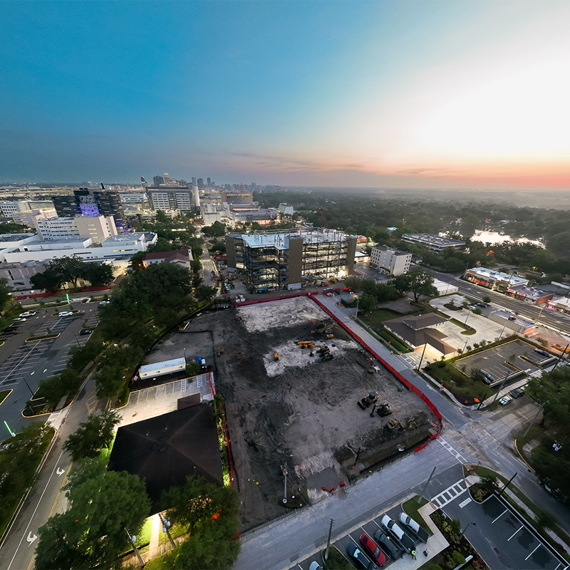 Aerial view of urban construction site with machinery at sunset.